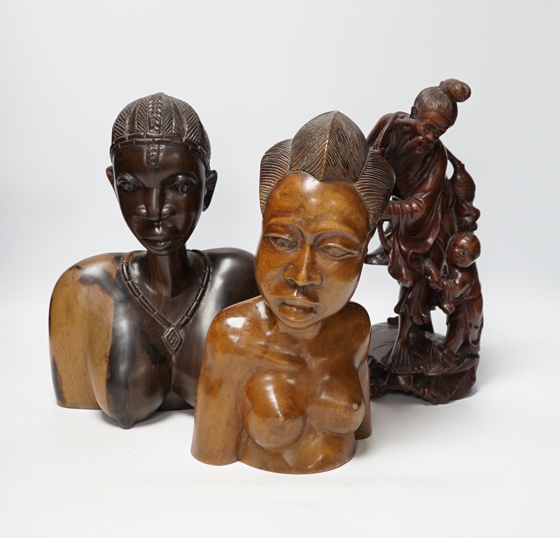 A Chinese carved rootwood figure emblematic of longevity on stand and two carved African busts, Chinese root carving 36cm high